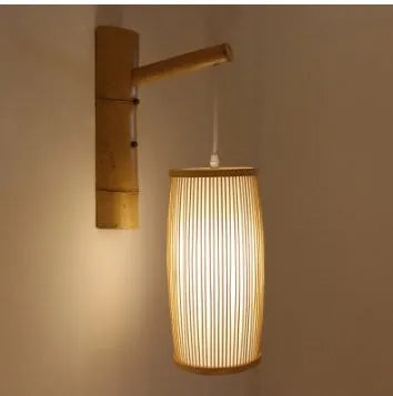 Natural bamboo plait cylindrical wall lamp with woven texture, shown mounted.