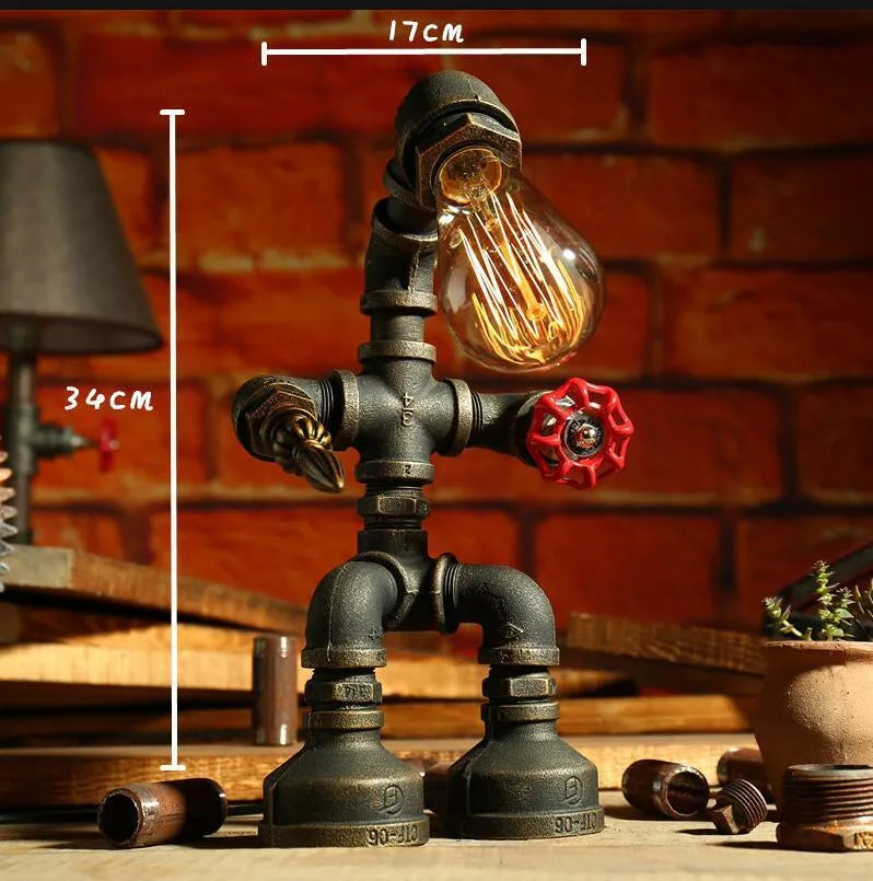 Green bronze vintage industrial robot desk lamp with iron pipe design on a wooden table.