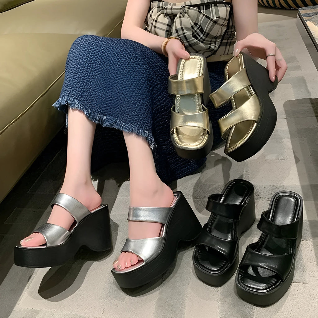 Women's black wedge platform slippers with a square toe on a white background.
