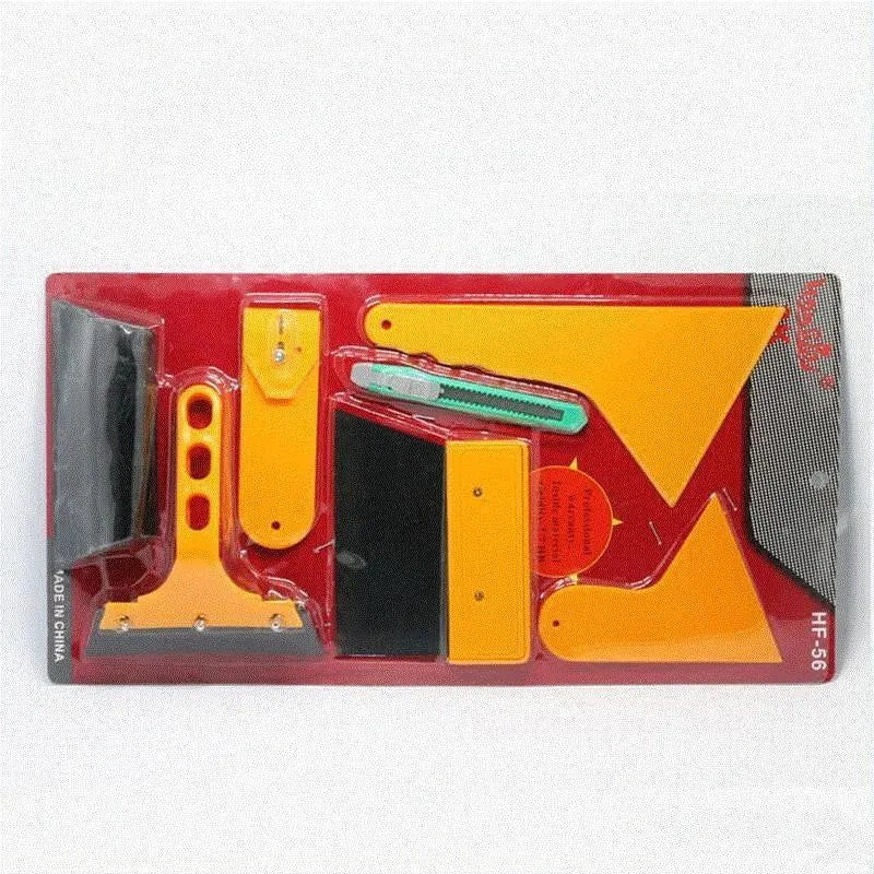 Seven-piece car film tool set with scrapers, knives, and a pressing block on a work surface.