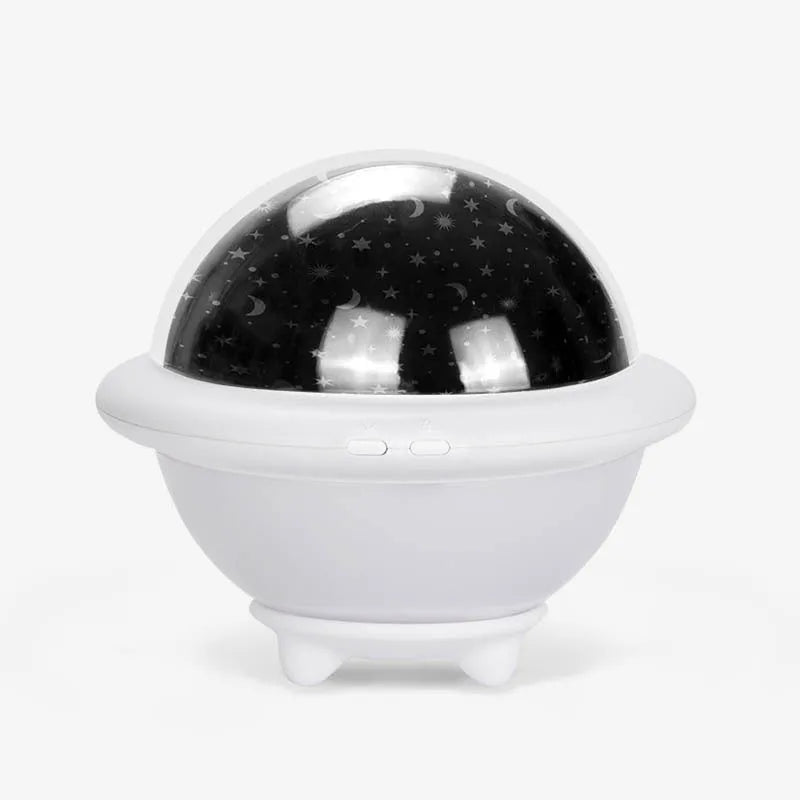Green UFO-shaped starry sky projection night light on a table, showing rotating planet display on wall.