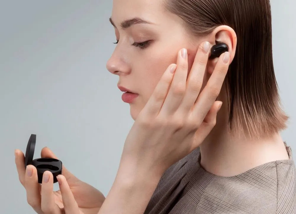 Redmi AirDots Black true wireless earbuds and their white charging case on a table