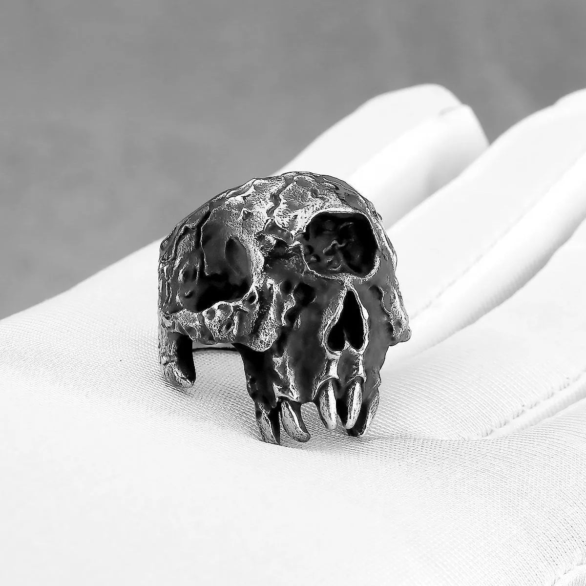 A close-up view of a silver-toned alloy ring featuring a detailed one-eyed skull design in a retro punk style.