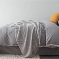 Small light grey polyester nap blanket folded, showing its 127cm by 170cm size.