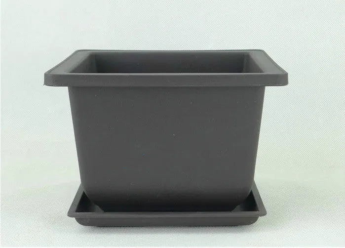 Dark brown antique recycled plastic flowerpot on a table.
