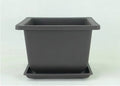 Dark brown antique recycled plastic flowerpot on a table.