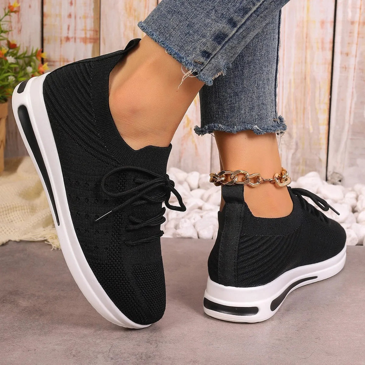 Women's low-top fly-knit sneakers in black, blue, or red with round toe and lace-up front.