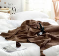 Nordic fringed knit ball acrylic blanket in beige colour, laid flat showing 130x170cm size and fringe detail