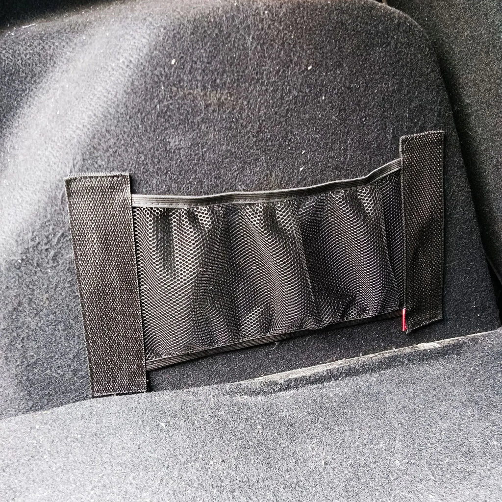 Elastic polyester storage net stretched in a car boot, holding shopping bags.