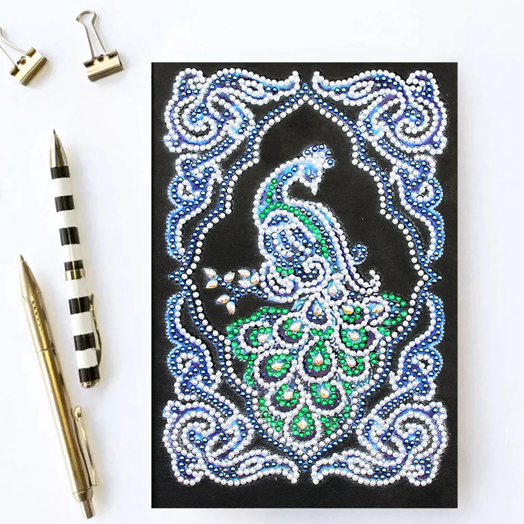 Black A5 diamond painting notebook with a peacock design cover, shown closed.