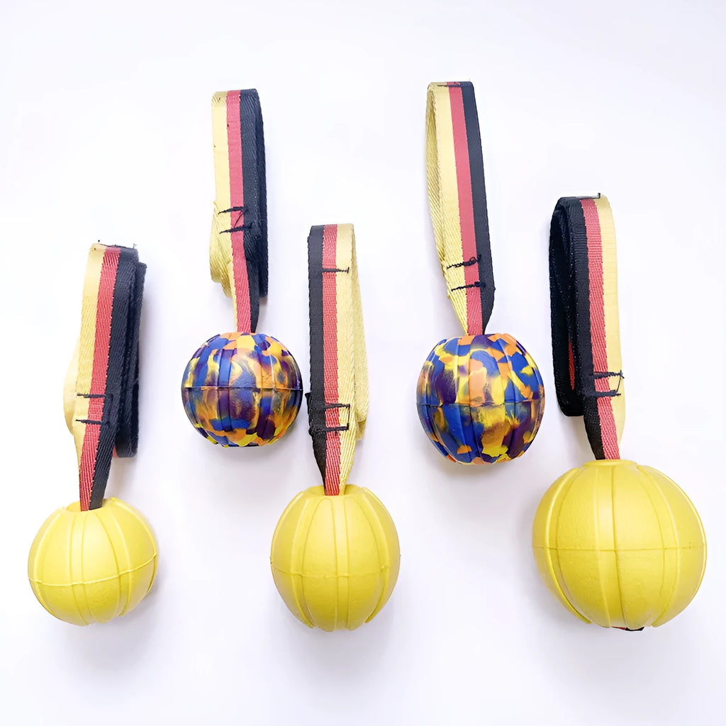 Camouflage and yellow floating EVA dog balls with tether strings in three different sizes on blue background.