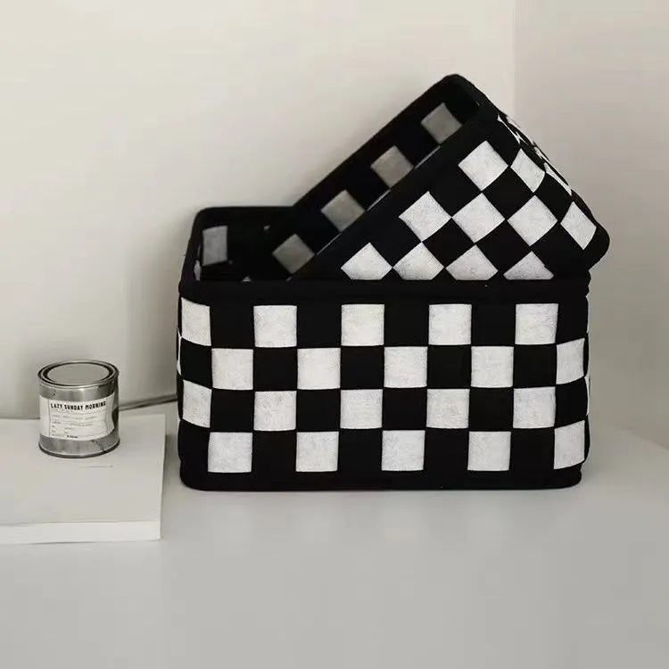 Checkerboard patterned grey and white felt folding storage box with woven design.