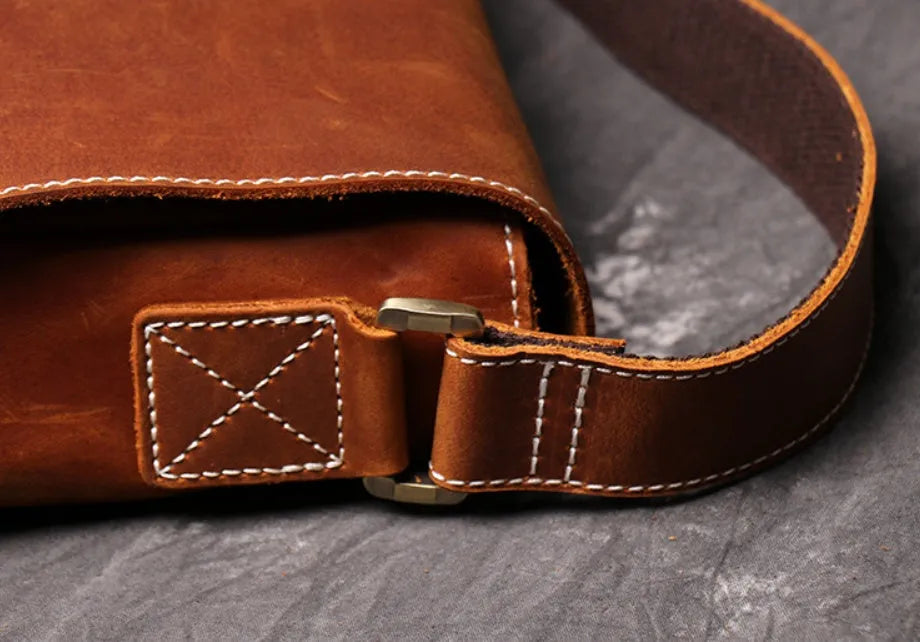 Brown vintage leather men's messenger bag with a flap opening and an adjustable shoulder strap.