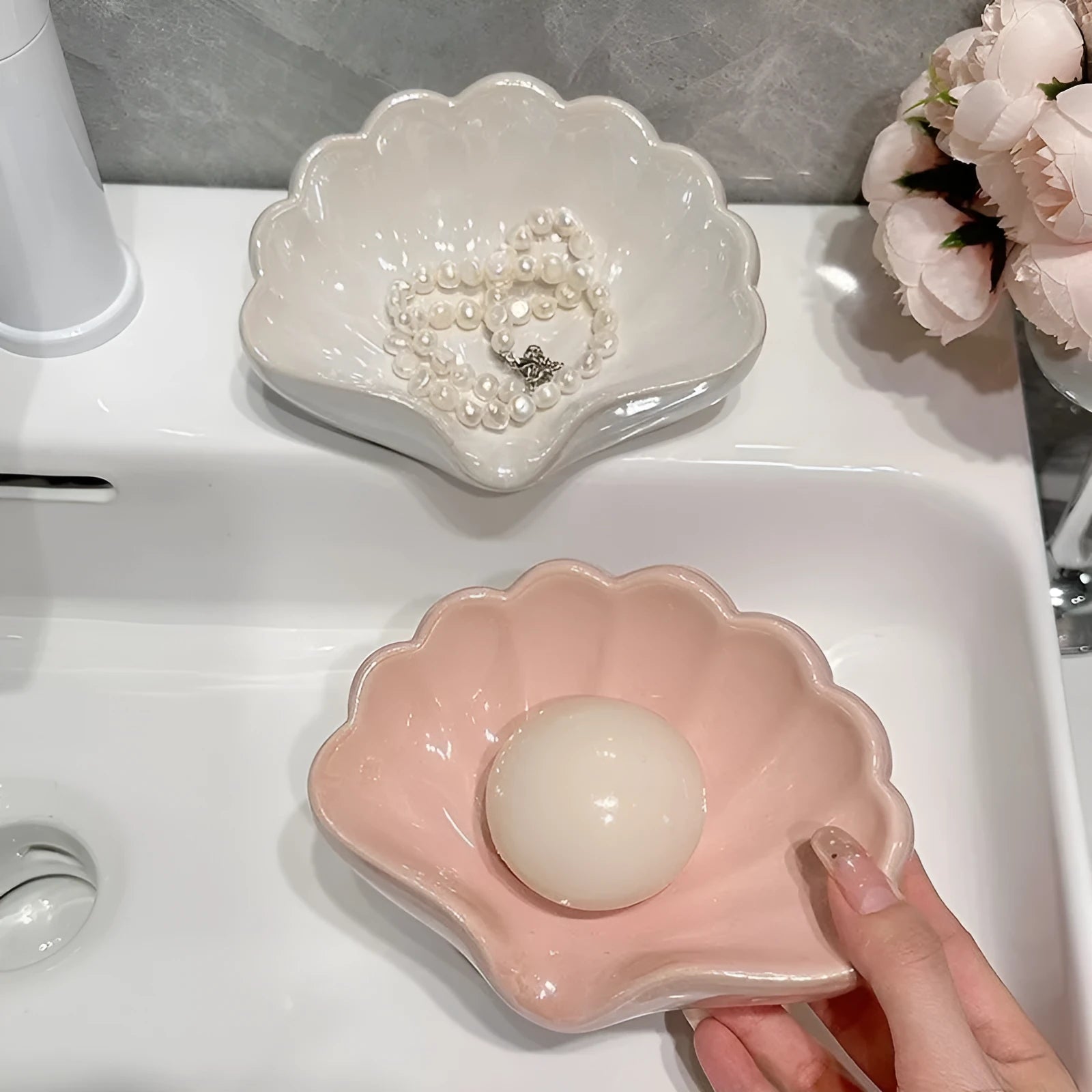 White shell-shaped plastic soap dish on a bathroom countertop.