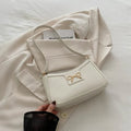 Western style PU leather shoulder bag with bow detail in horizontal square shape.