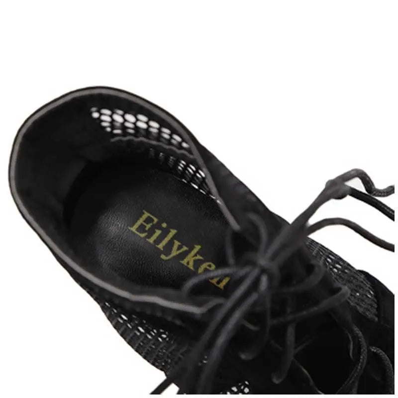 Black suede women's lace-up high heel shoes with 11.5cm heel on wooden floor