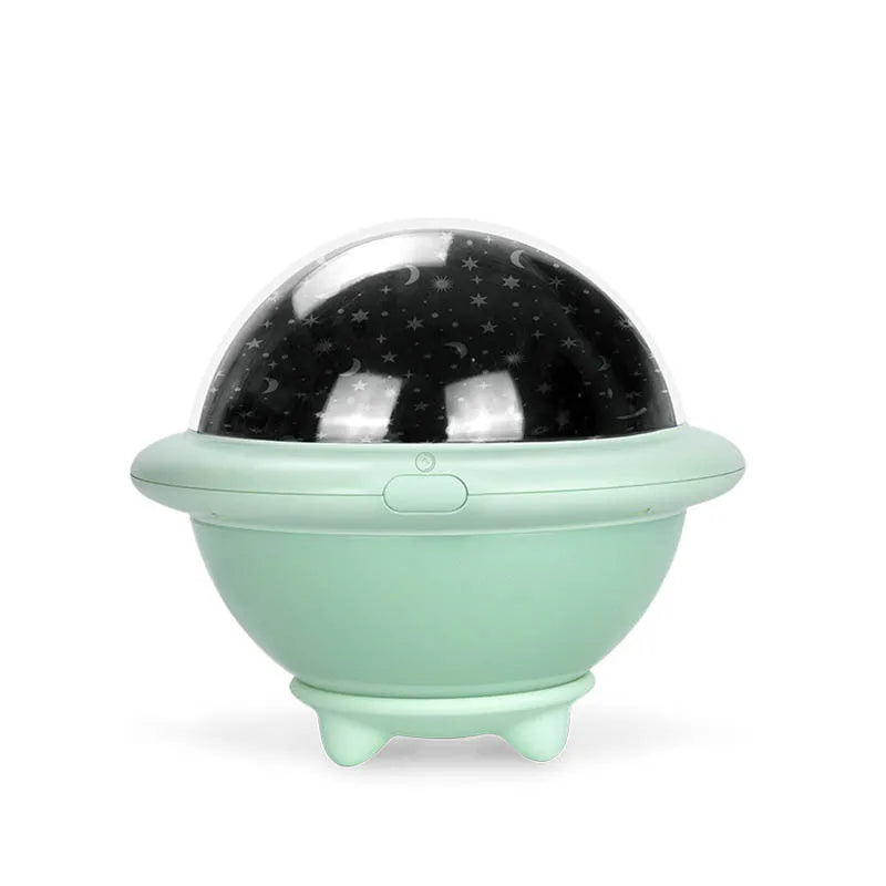 Green UFO-shaped starry sky projection night light on a table, showing rotating planet display on wall.