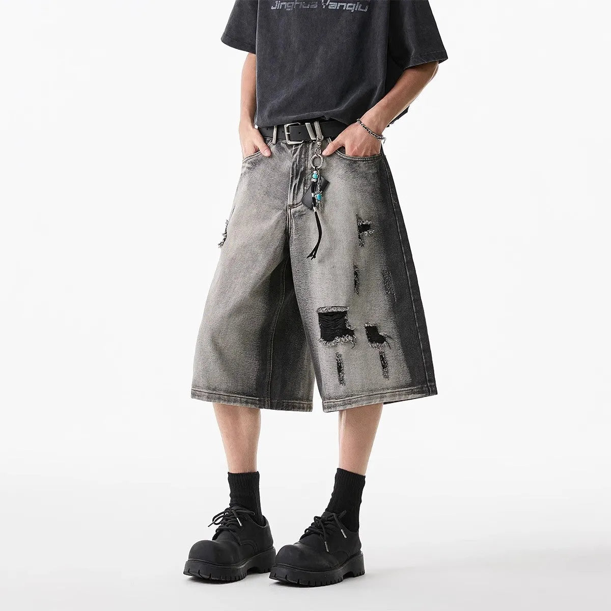 Grey loose-fit denim shorts with a water-washed finish and distressed hole details.
