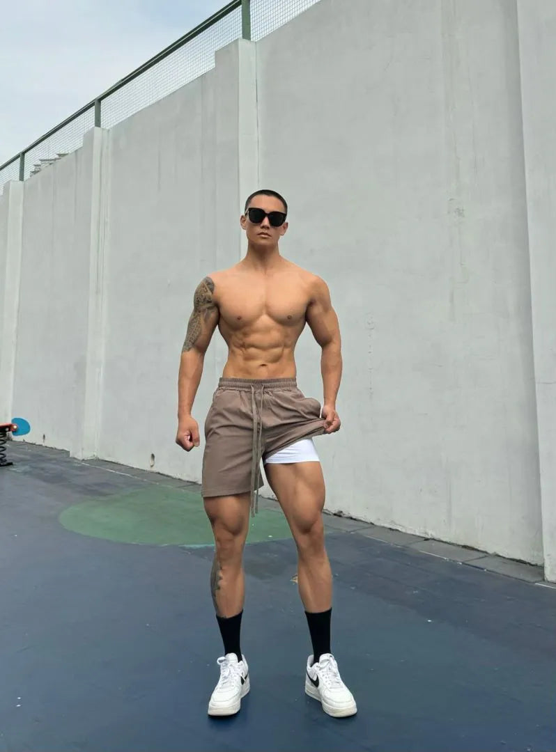 Men's ice silk quick-drying double-layer shorts in light grey, showing casual fit and elastic waistband.