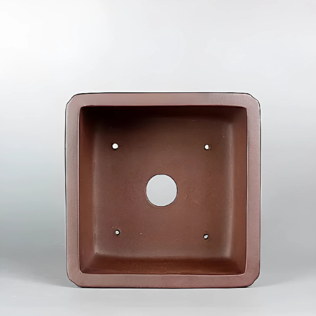 Brown antique classical style purple clay flower pot for plants on a windowsill.