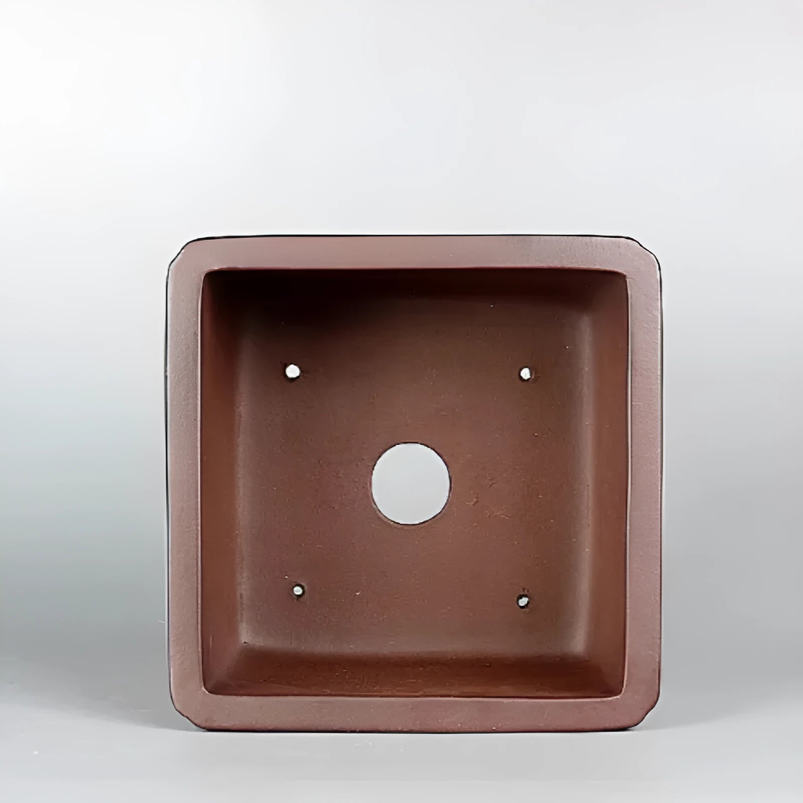 Brown antique classical style purple clay flower pot for plants on a windowsill.