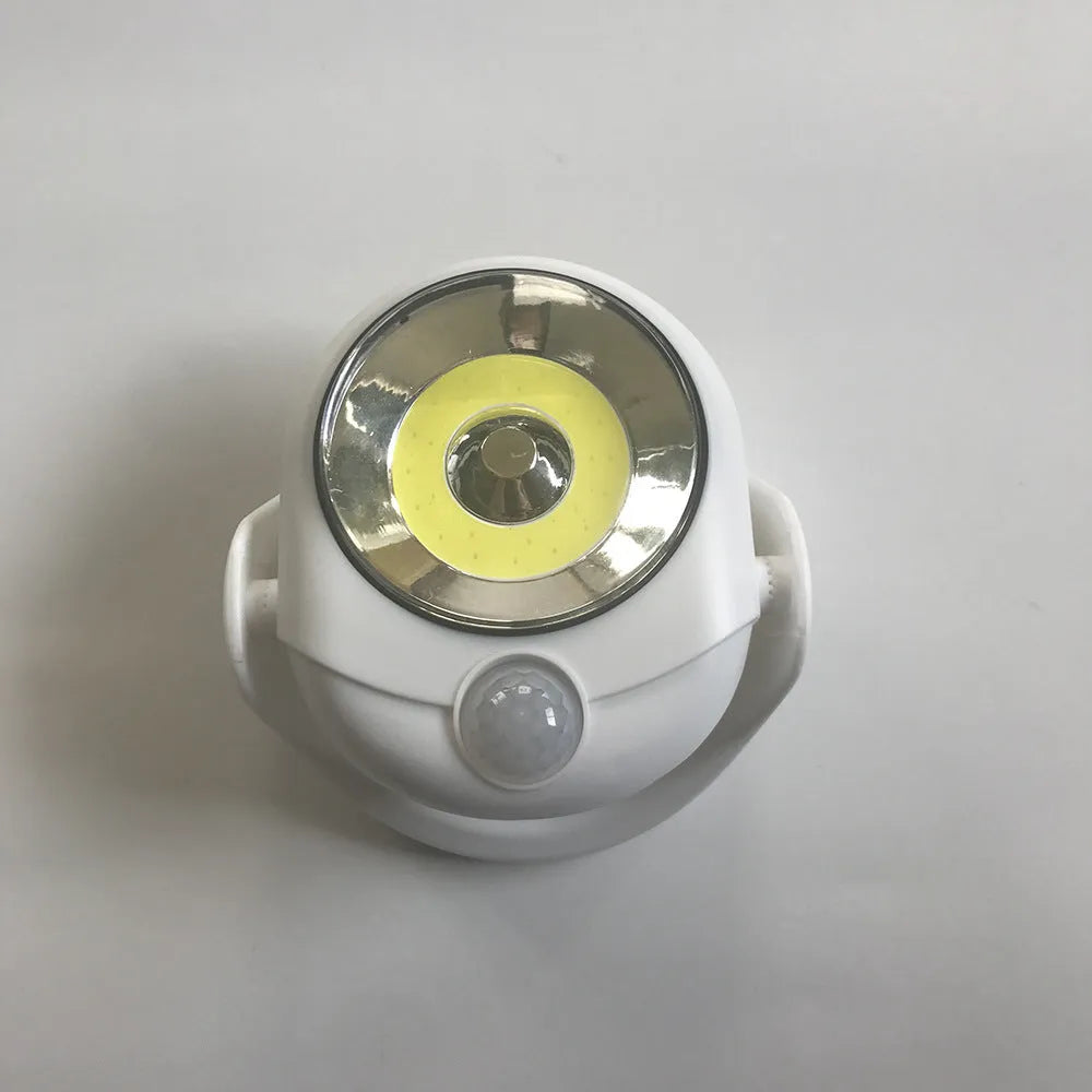 White Atomic Angel induction-activated LED night light on a surface.