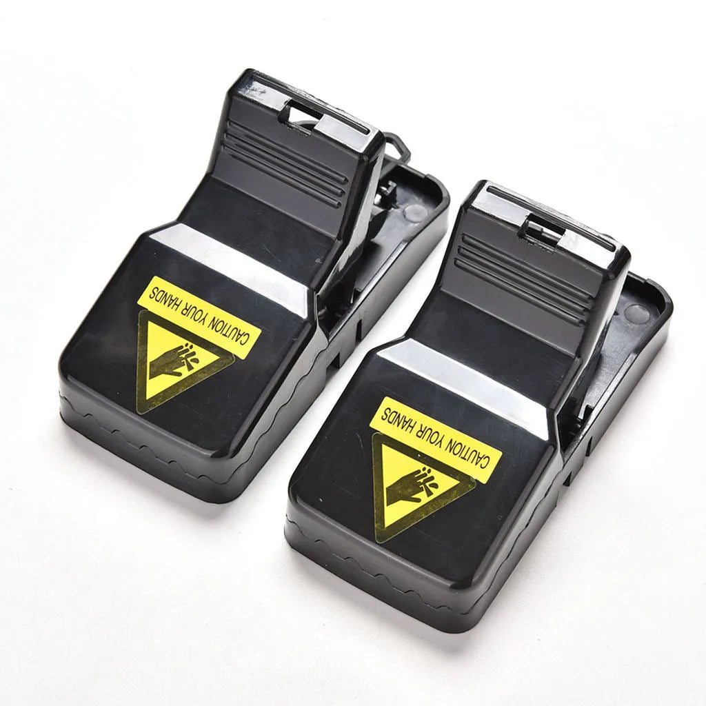 Six black plastic snap-action mousetraps showing their size and smooth surface.