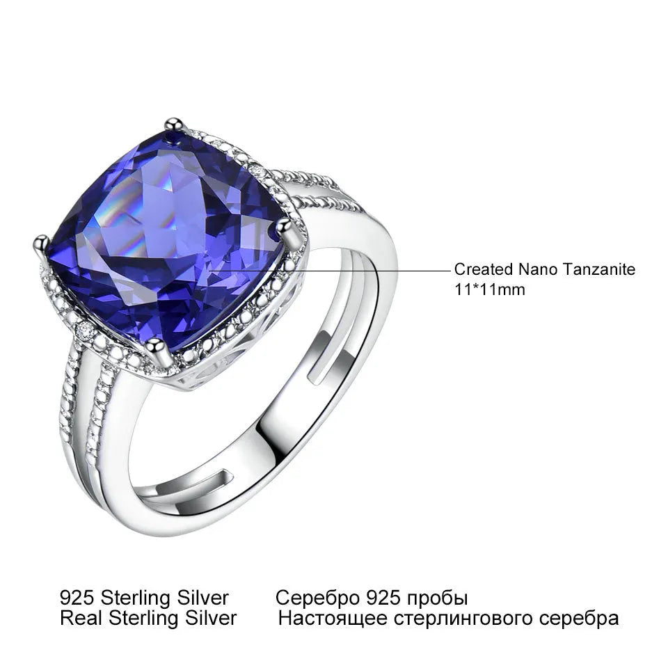 Close-up of a blue tanzanite stone set in a sterling silver women's ring on a grey background.