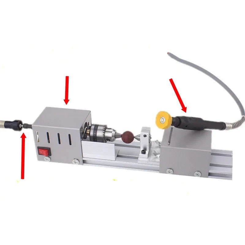 Silver metal mini woodworking lathe with carving knives on a workbench
