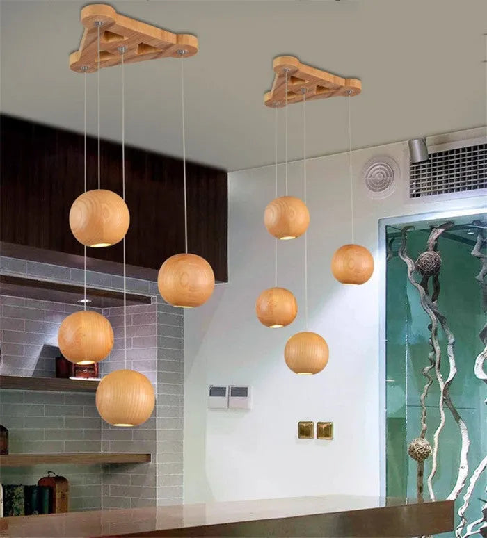 Nordic-style wooden ball chandelier with adjustable cord, shown in single-head and three-head styles on a wood disc base.