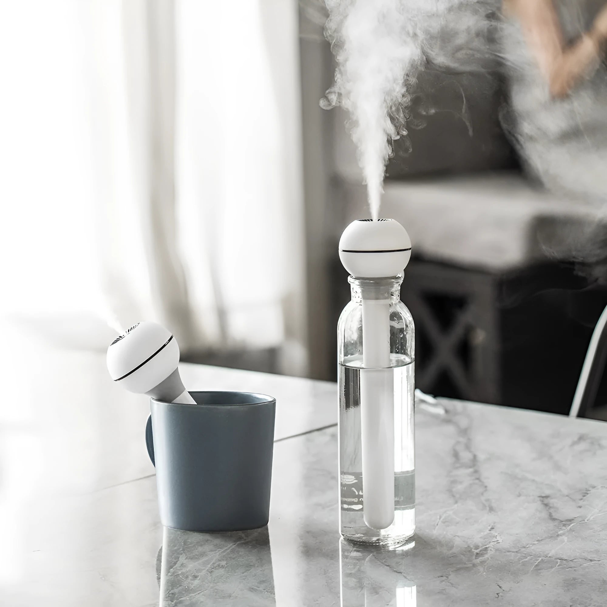 A columnar pink and white personal USB magic wand humidifier on a table.