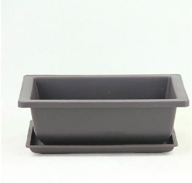Dark brown antique recycled plastic flowerpot on a table.