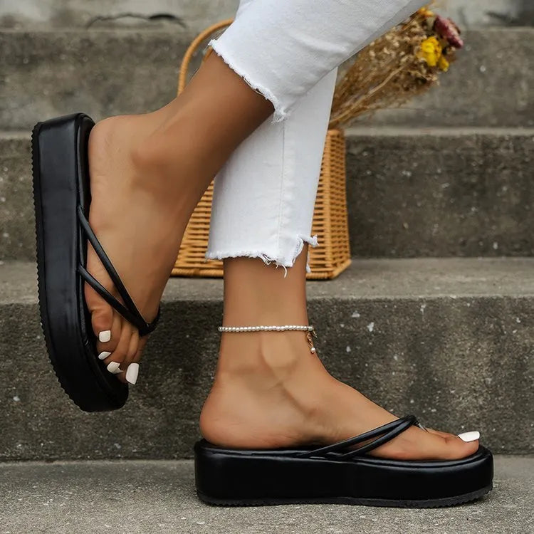 White thick bottom flip-flops with herringbone pattern and round toe on a rubber sole.