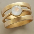 Geometric gold-plated titanium steel ring with hollow framework and micro-inlaid white chalcedony stone