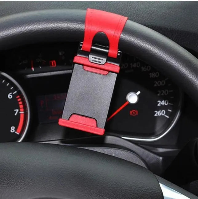 Black steering wheel phone holder clip mounted on car steering wheel holding a smartphone