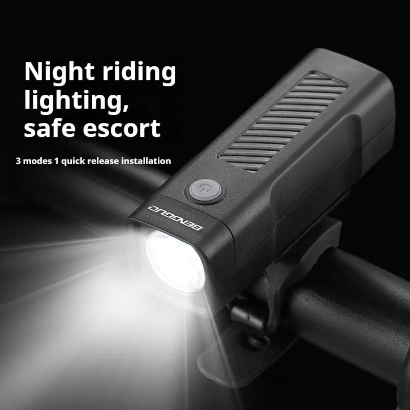A black USB-rechargeable bicycle headlight mounted on a handlebar with a quick-release strap.