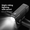 A black USB-rechargeable bicycle headlight mounted on a handlebar with a quick-release strap.