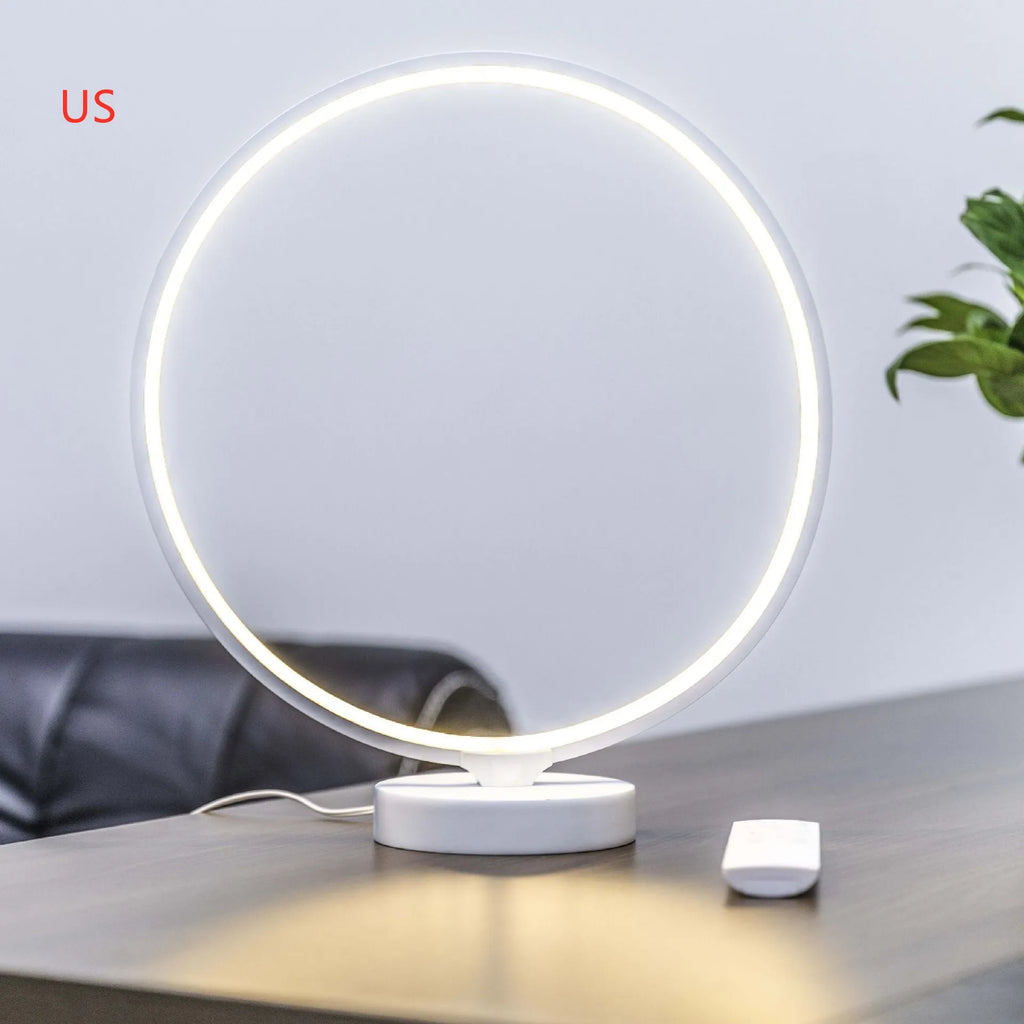 White spherical Full Moon table lamp with remote control on a wooden surface.