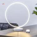 White spherical Full Moon table lamp with remote control on a wooden surface.