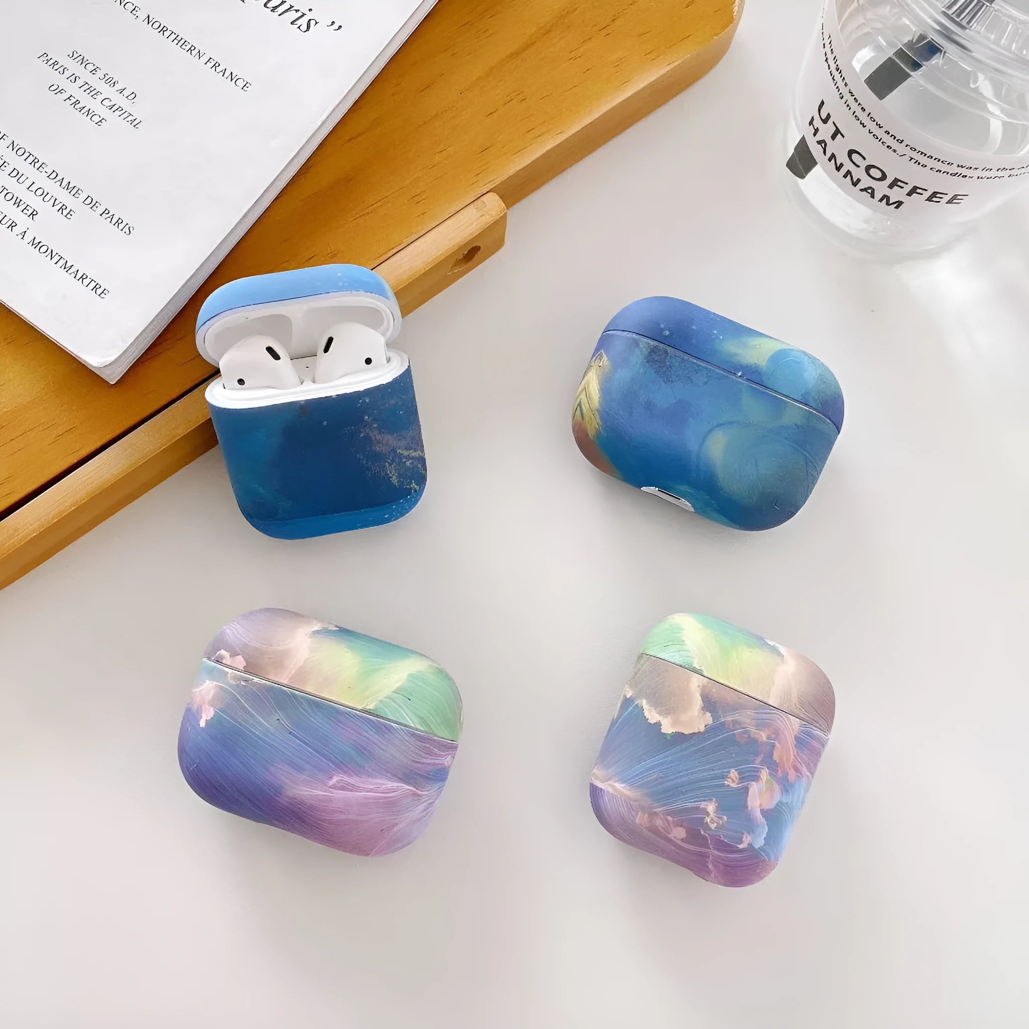 Hard plastic protective sleeve for Apple AirPods case in a blue watercolour design.