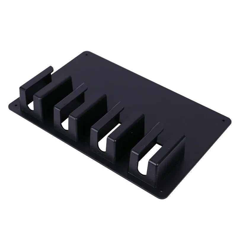 Black plastic wall-mounted frame holding four electric hair clippers.