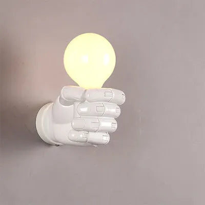 Sculptural resin fist wall lamp in black, white, or wood grain finish for decorative lighting.