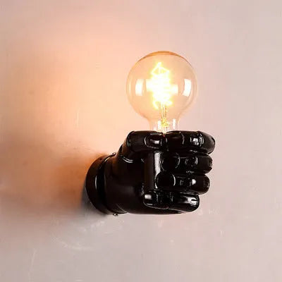 Sculptural resin fist wall lamp in black, white, or wood grain finish for decorative lighting.