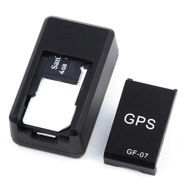 Small black plastic magnetic GPS car tracker device on a metal surface.