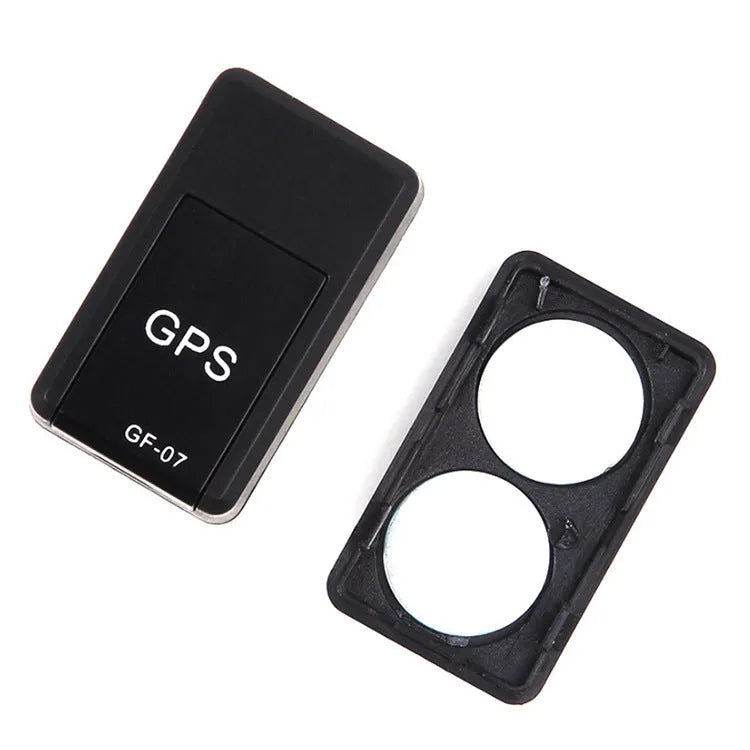Small black plastic magnetic GPS car tracker device on a metal surface.