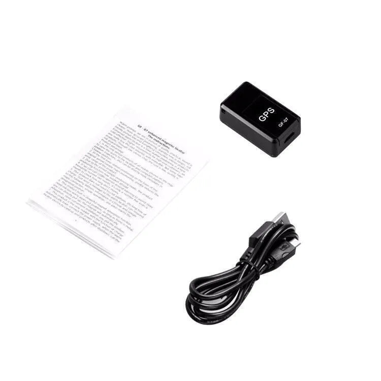 Small black plastic magnetic GPS car tracker device on a metal surface.