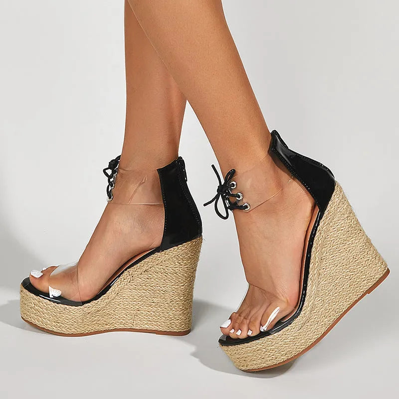 Black women's wedge sandals with hemp rope straps and a tall platform wedge heel, showing front tie closure.