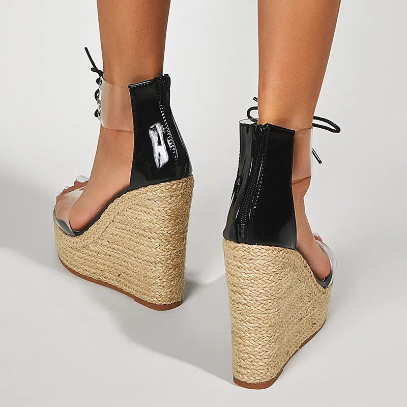 Black women's wedge sandals with hemp rope straps and a tall platform wedge heel, showing front tie closure.