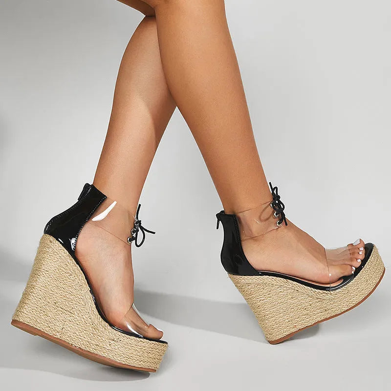 Black women's wedge sandals with hemp rope straps and a tall platform wedge heel, showing front tie closure.