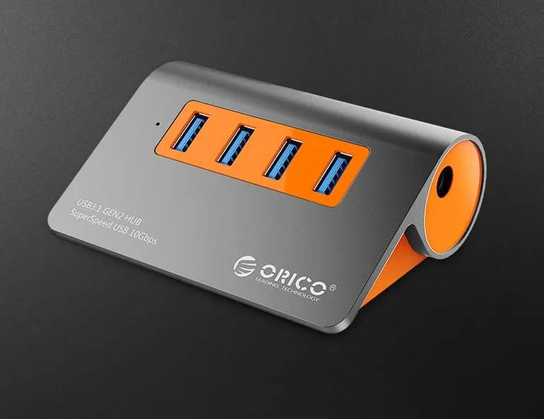 Dark grey and orange aluminium USB hub with four ports and a long black data cable.